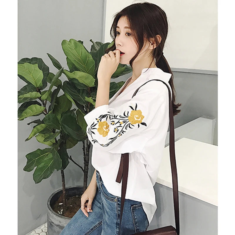 Estilo casual com toque delicado! Blusa feminina branca com listras, bordado floral e decote V elegante. Modelagem soltinha com manga 3/4, perfeita para looks leves e modernos.