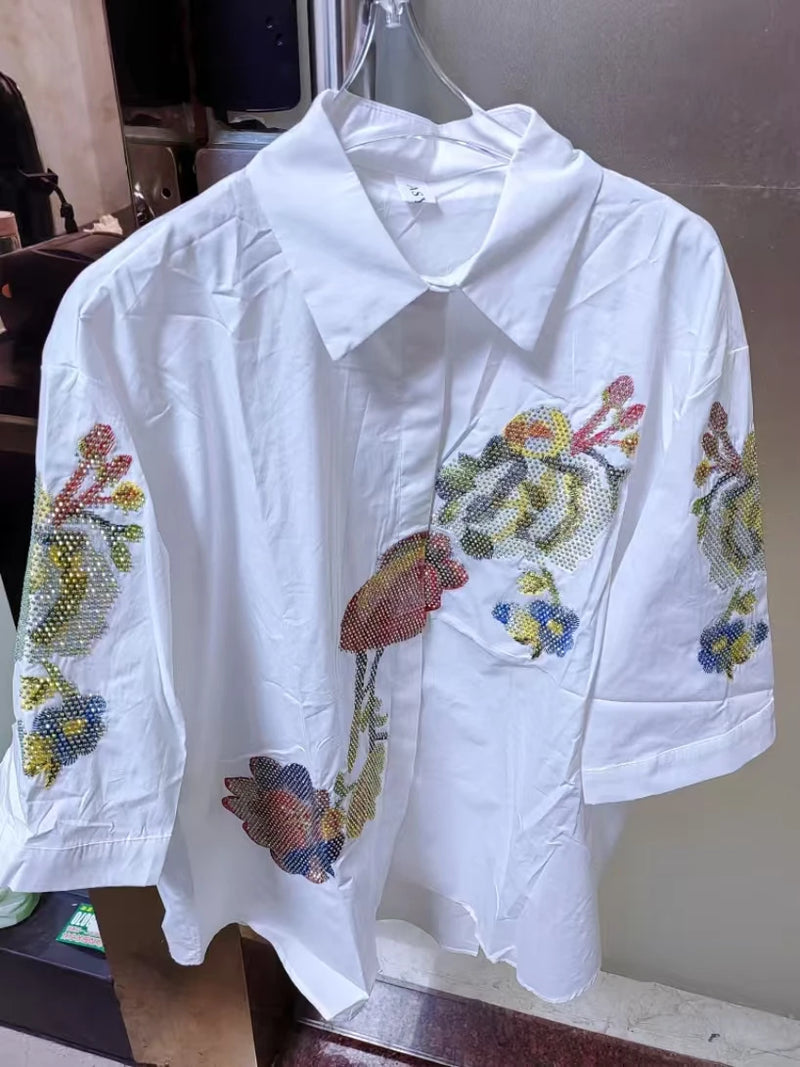 Adicione um toque delicado e elegante ao seu guarda-roupa com esta blusa feminina bordada com flores. Confeccionada em 100% algodão puro, é leve, respirável e confortável, perfeita para o verão.