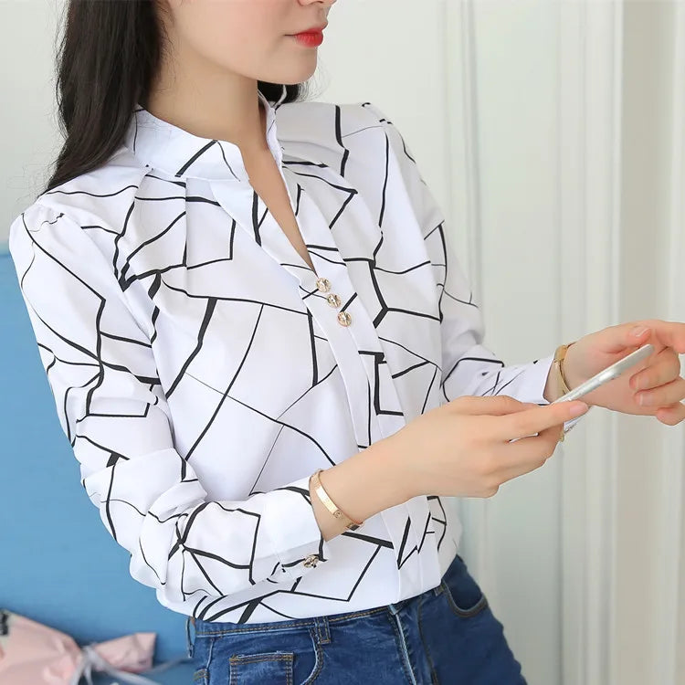 Blusa feminina elegante em tecido leve, com estampa listrada e mangas longas. Corte slim fit, perfeita para o escritório, reuniões ou looks casuais-chiques.