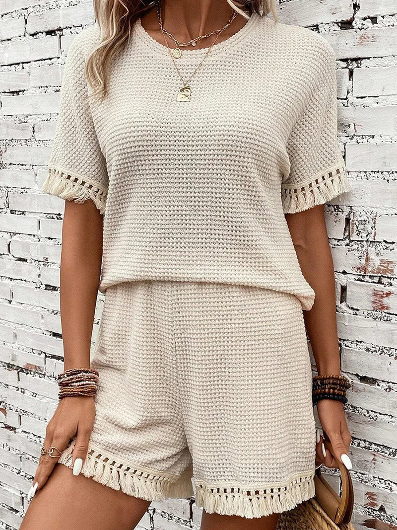 onjunto feminino leve e confortável para o verão 2025, composto por blusa solta com franjas e shorts combinando. Estilo casual e streetwear, perfeito para passeios na praia, férias ou look diário despojado.