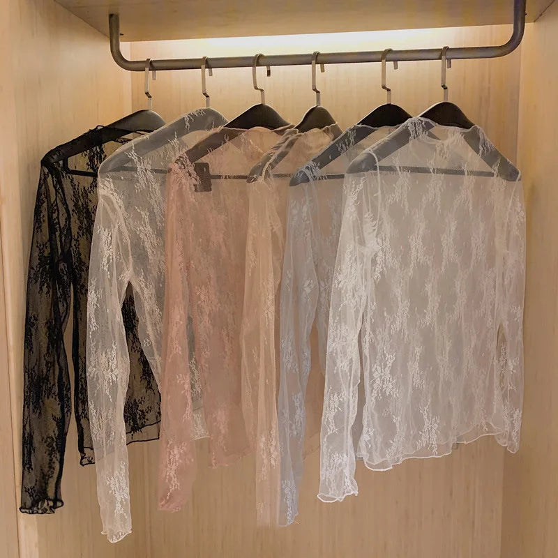Blusa feminina elegante em renda e tule transparente, com gola alta (turtleneck) e mangas longas. Modelo justo e moderno, perfeito para looks casuais ou para sobreposição em composições sofisticadas