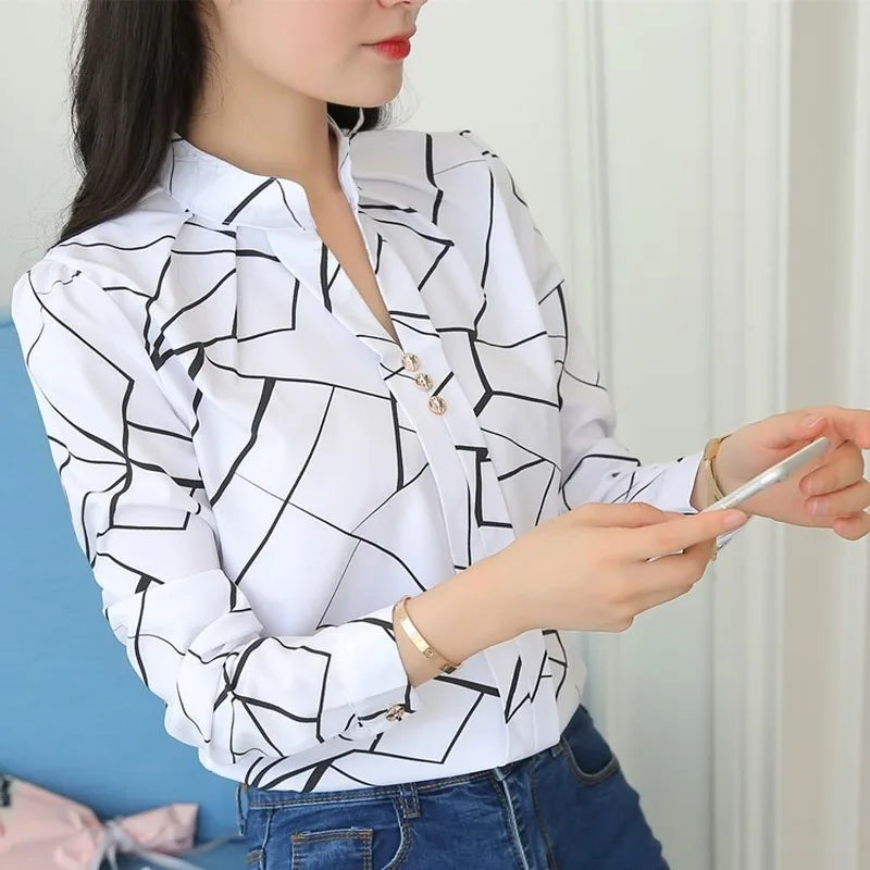 Blusa feminina elegante em tecido leve, com estampa listrada e mangas longas. Corte slim fit, perfeita para o escritório, reuniões ou looks casuais-chiques.