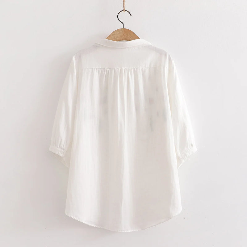Camisa feminina 100% algodão, leve e respirável, perfeita para o verão. Com mangas 3/4 e delicado bordado, combina elegância e conforto. Ideal para trabalho, passeios ou ocasiões casuais.