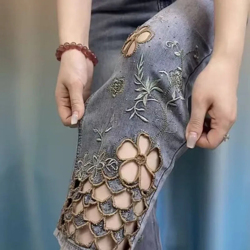 Calça feminina de alta qualidade, com bordado sofisticado e recortes vazados. Estilo tubo cigarette, cintura alta e tecido leve, perfeita para um look moderno e elegante no verão.