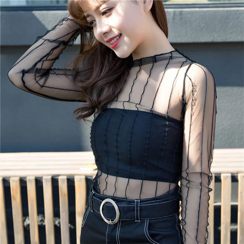 Blusa feminina elegante em renda e tule transparente, com gola alta (turtleneck) e mangas longas. Modelo justo e moderno, perfeito para looks casuais ou para sobreposição em composições sofisticadas