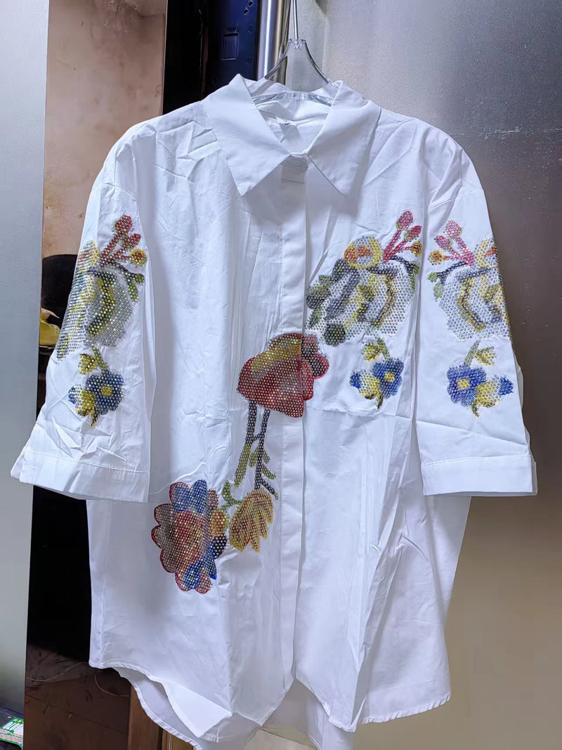 Adicione um toque delicado e elegante ao seu guarda-roupa com esta blusa feminina bordada com flores. Confeccionada em 100% algodão puro, é leve, respirável e confortável, perfeita para o verão.