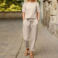 Conjunto elegante e confortável para o verão 2024, composto por blusa de manga curta com decote redondo e calça pantalona com cintura elástica e amarração. Estilo retrô moderno, ideal para looks casuais